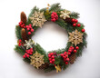 © Saddha Visual - Festive Christmas wreath. Round frame made of conifer branches decorated with cones, artificial red berries and decorative gold snowflakes. Wreath isolated on white background