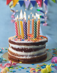 A delightful birthday cake with lit candles, colorful sprinkles, and festive confetti. Celebrate joy!