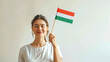 © chekart - A woman holds a stick with a small Hungarian flag in her hand. Striped red-white-green Hungarian flag. Independence Day. The concept of patriotism and pride. The national symbol