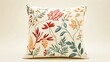 © fivan - A square cushion with intricate embroidery, isolated against a soft cream background with subtle botanical illustrations
