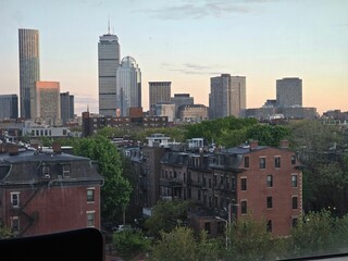 City skyline with modern skyscrapers and historic buildings at sunset.