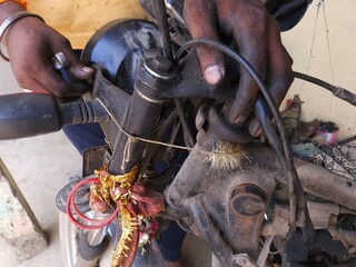 Close Up of motorbike mechanic busy repairing bike at garage. Industry concept of professional occupation, repair man and skill labor.