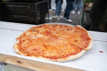 Simple display of a classic cheese pizza, cut into slices and ready to be served