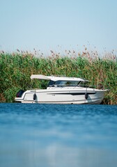 Motorboat on a tranquil lake by reeds.