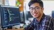 © Lion - Asian man coding at his computer, smiling while working as a programmer, simple composition with minimal distractions.