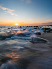 Wall Mural - sunrise view along the rocky beach coastline.