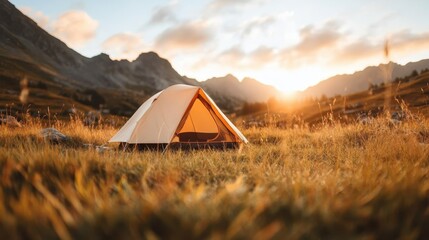 a solitary tent resides quietly amidst an expansive mountainscape as the sun sets, casting golden hu