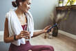 © Dragana Gordic - Woman Relaxing After Yoga Workout and Checking Phone