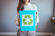 © Dragana Gordic - Woman Holding Blue Recycling Bin With Green Recycling Symbol