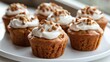 © savittree - A delightful serving of vegan carrot muffins with a nutty cream topping on a white plate, radiating warmth and inviting everyone to enjoy.