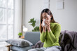 © Wasana - Sick asian woman sneezing in tissue at home on sofa