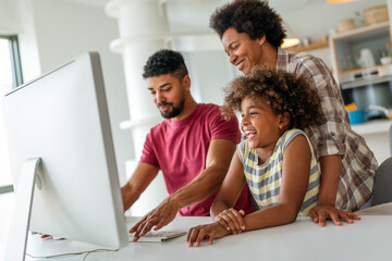 Wall Mural - Happy african american family having fun together while using computer together at home