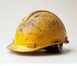 © olegganko - Worn yellow construction helmet placed on a clean surface highlighting its rugged features