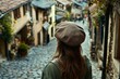 © vasyan_23 - Charming old town street with woman in beret exploring cobblestone pathway