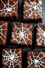 chocolate brownies with white spider web designs on top