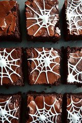 chocolate brownies with white spider web designs on top