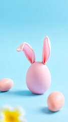 pink egg with bunny ears on a light blue background