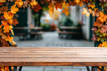 Poster - Empty wooden table with blurred background of an outdoor restaurant decorated with autumn leaves
