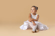 © New Africa - Portrait of little ballerina on beige background, space for text