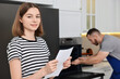 © New Africa - Smiling woman with sheet of paper and repairman fixing oven in kitchen, selective focus