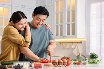 Wall Mural - Happy lovely couple cooking together in kitchen