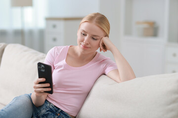 Sticker - Beautiful woman using smartphone on sofa indoors