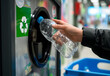 © Наталья Лазарева - person is recycling plastic bottle at reverse vending machine, promoting environmental sustainability and eco-friendly practices for use in educational,green living,or environmental awareness projects