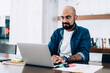 © BullRun - Bearded ethnic man working on laptop