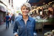 © Markus Schröder - Portrait of a blissful woman in her 50s sporting a versatile denim shirt over bustling urban market
