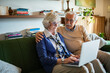 © Geber86 - Senior couple using laptop together on couch at home