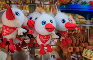 Wall Mural - Colmar, France - June 5, 2023: Traditional Alsatian gingerbread man plush toys and stork stuffed animals on display at a souvenir store in old town