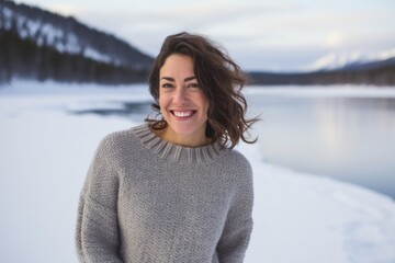 Sticker - Portrait of a joyful woman in her 30s wearing a cozy sweater isolated in backdrop of a frozen winter lake