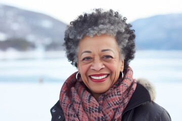 Sticker - Portrait of a grinning afro-american woman in her 80s dressed in a polished vest over backdrop of a frozen winter lake