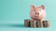 © Guga - Piggy bank with copy space, light blue background and a few stacked coins