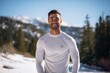 © Markus Schröder - Portrait of a grinning man in his 20s sporting a long-sleeved thermal undershirt on pristine snowy mountain