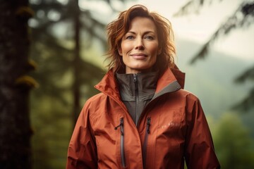 Poster - Portrait of a blissful woman in her 40s wearing a functional windbreaker in front of backdrop of a mystical forest