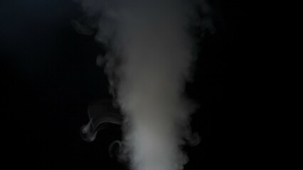 Wall Mural - close-up of white smoke clouds against a black background. contrast of brightly lit smoke and dark r