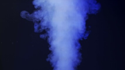 Wall Mural - close-up stream of white smoke on a black background with blue neon light. contrast of brightly lit 