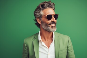 Portrait of a blissful man in his 40s wearing a trendy sunglasses isolated in pastel green background