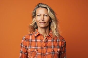 Canvas Print - Portrait of a glad woman in her 40s dressed in a relaxed flannel shirt over pastel orange background