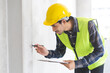 © KMPZZZ - Building inspection asian contractor young man, male inspecting home, reconstructed construction, renovation or check defect, before finish handing it over to client, customer. Engineering worker.