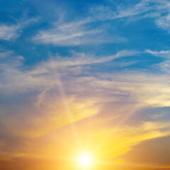 Wall Mural - bright orange sun against blue sky.