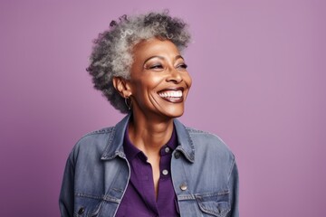 Sticker - Portrait of a happy afro-american woman in her 70s sporting a rugged denim jacket isolated on soft purple background