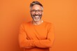 © Markus Schröder - Portrait of a joyful man in his 40s donning a trendy cropped top in soft orange background