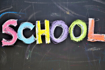 the word school on coloful chalkboard over a blackboard, back to classes concept, education and learning