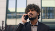 © Yuliia - Angry stressed difficult man business mad aggressive furious entrepreneur male Indian employer Arabian businessman feel anger shouting talking mobile phone argue conversation conflict quarrel in city