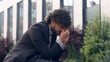 © Yuliia - Tired stressful worried bad feeling frustrated Indian businessman Arabian sad upset Hispanic business man stress problem bankruptcy debt failure corporate trouble headache reaction in city outdoors