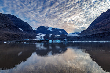 Wall Mural - mirror reflection of a glacier and mountains of vikinge bay, scoresby sund, greenland. beautiful sun