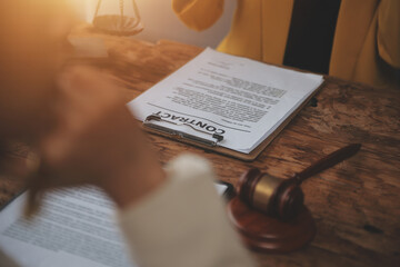 Business and lawyers discussing contract papers with brass scale on desk in office. Law, legal services, advice, justice and law concept picture with film grain effect