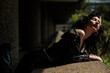 © Jorge Elizaquibel - Female rock star leaning on concrete banister and enjoying sunlight.